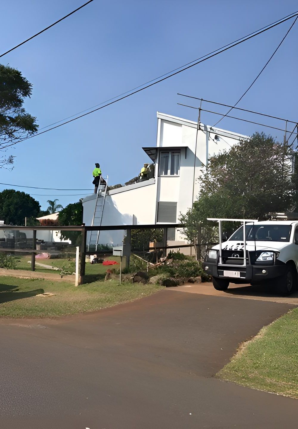 A White Truck is Parked in Front of a White Building — Roofing Revamped in Maroochydore, QLD