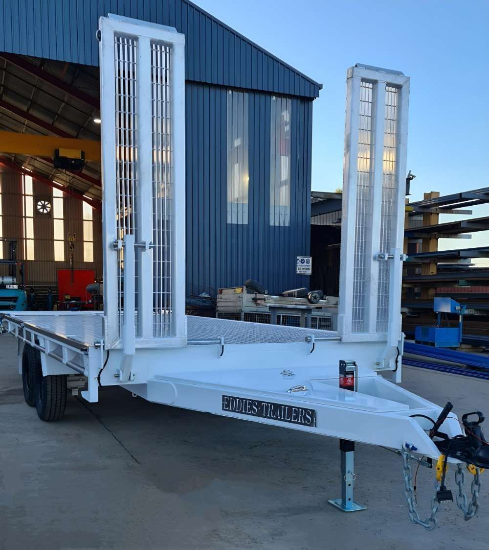 A White Trailer Is Parked In Front Of A Blue Building — Eddies Trailers & Fab in Muswellbrook, NSW