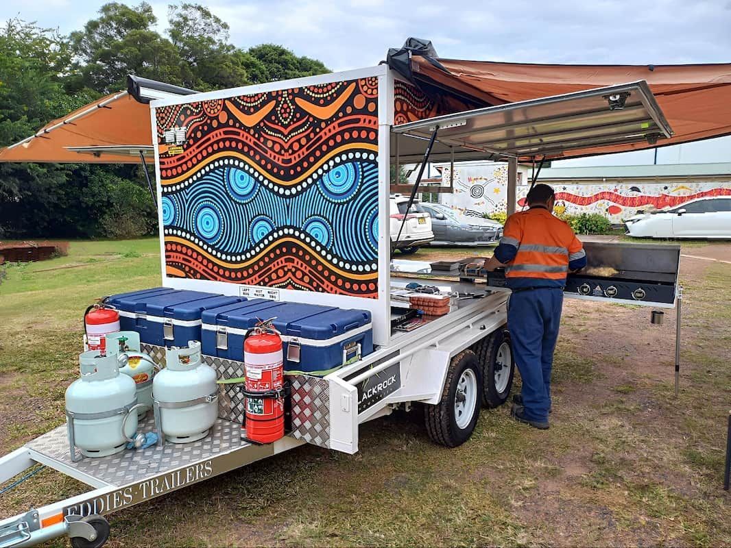 A Man Is Standing in Front of A Trailer with A Painting on It — Eddies Trailers & Fab in Muswellbrook, NSW