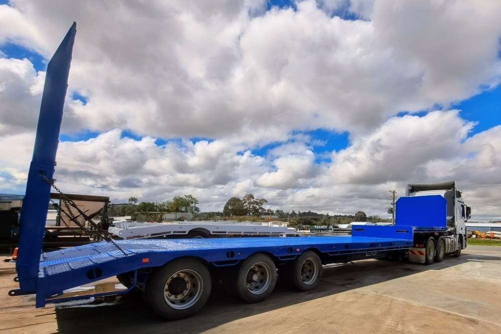 A Blue Flatbed Trailer Is Parked In A Parking Lot — Eddies Trailers & Fab in Muswellbrook, NSW