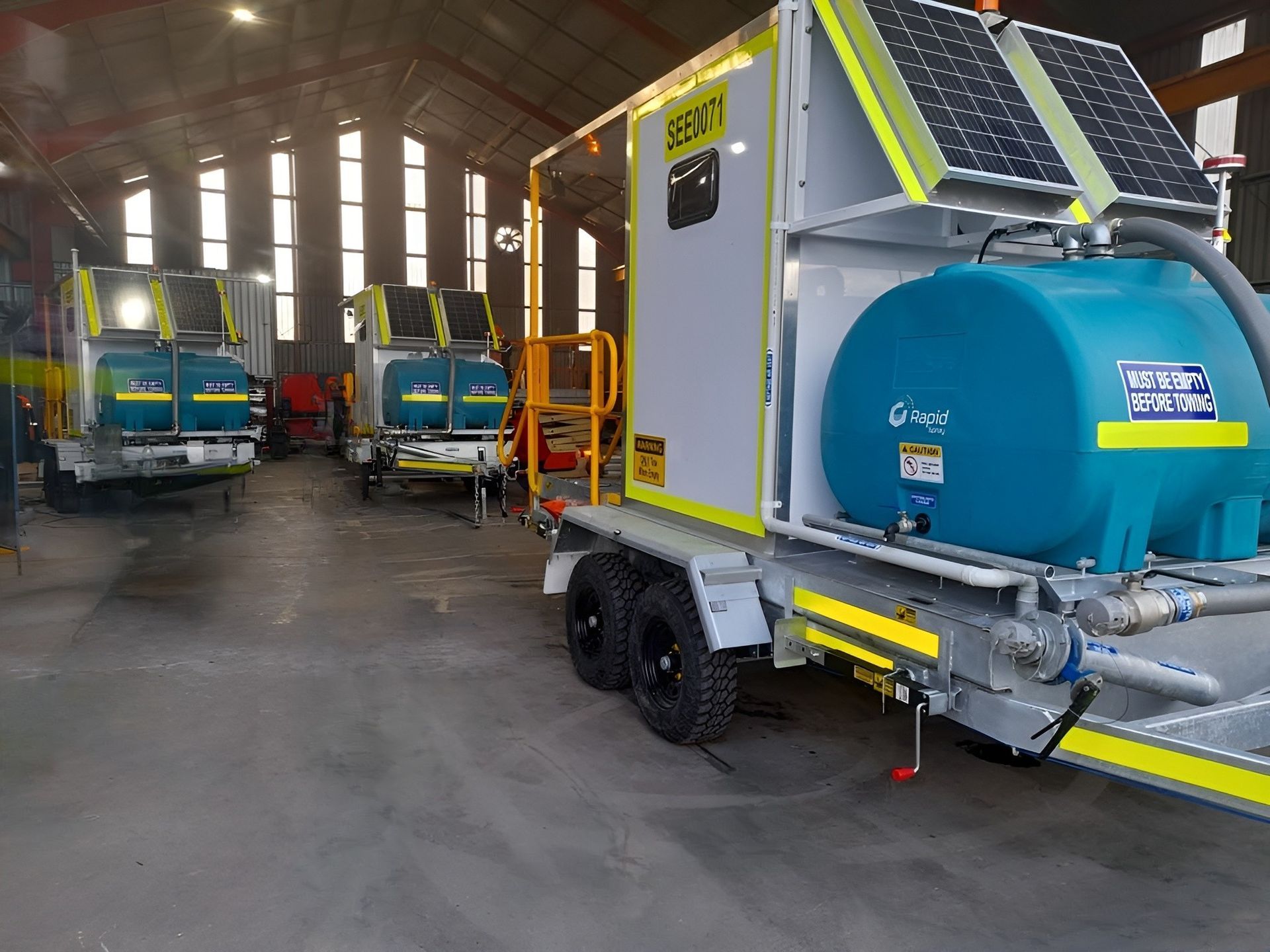 A trailer with a solar panel on top of it is parked in a garage.