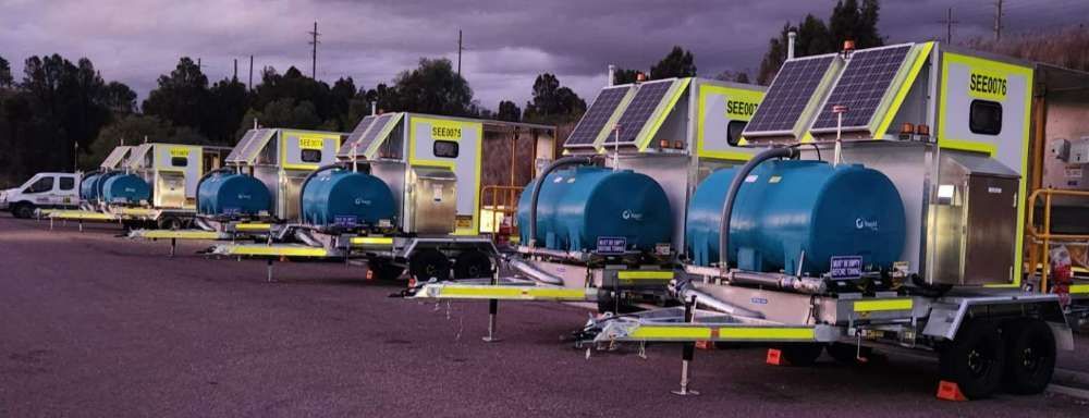 A Row Of Trailers With Blue Tanks On Them Are Parked In A Parking Lot — Eddies Trailers & Fab in Muswellbrook, NSW