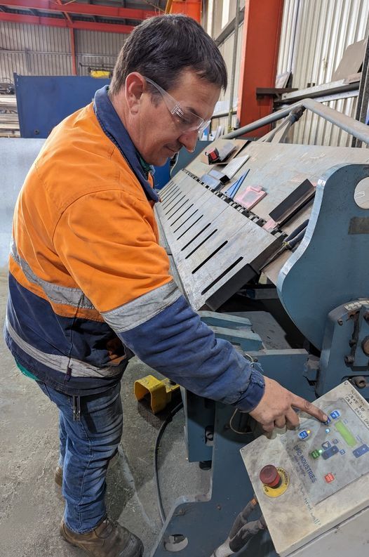 A Man Is Working on A Machine in A Factory — Eddies Trailers & Fab in Newcastle, NSW