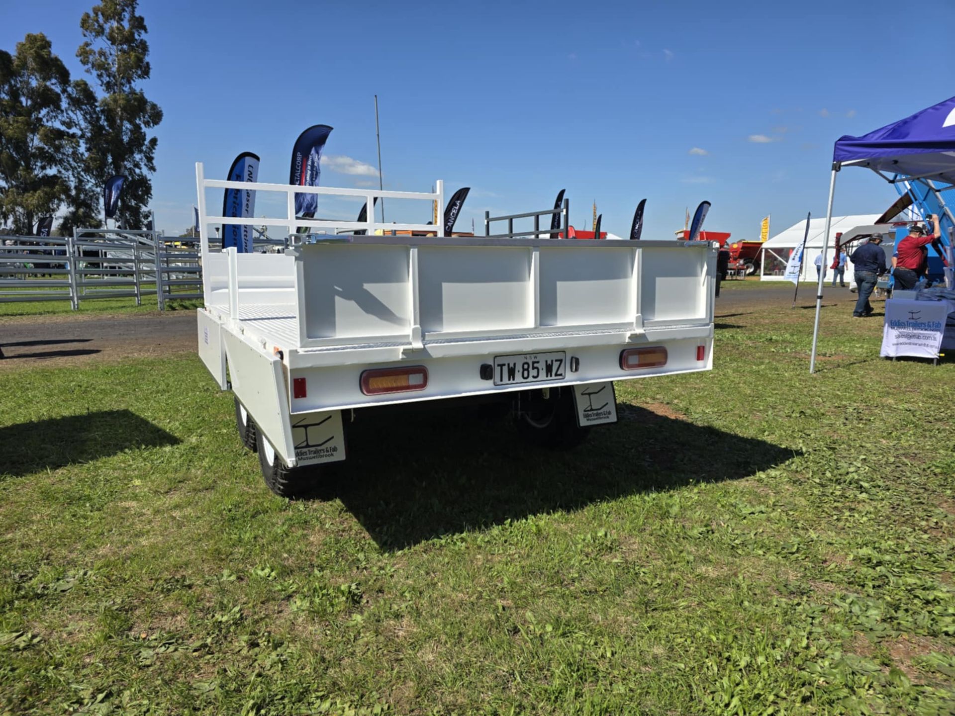 A white truck is parked in a grassy field.