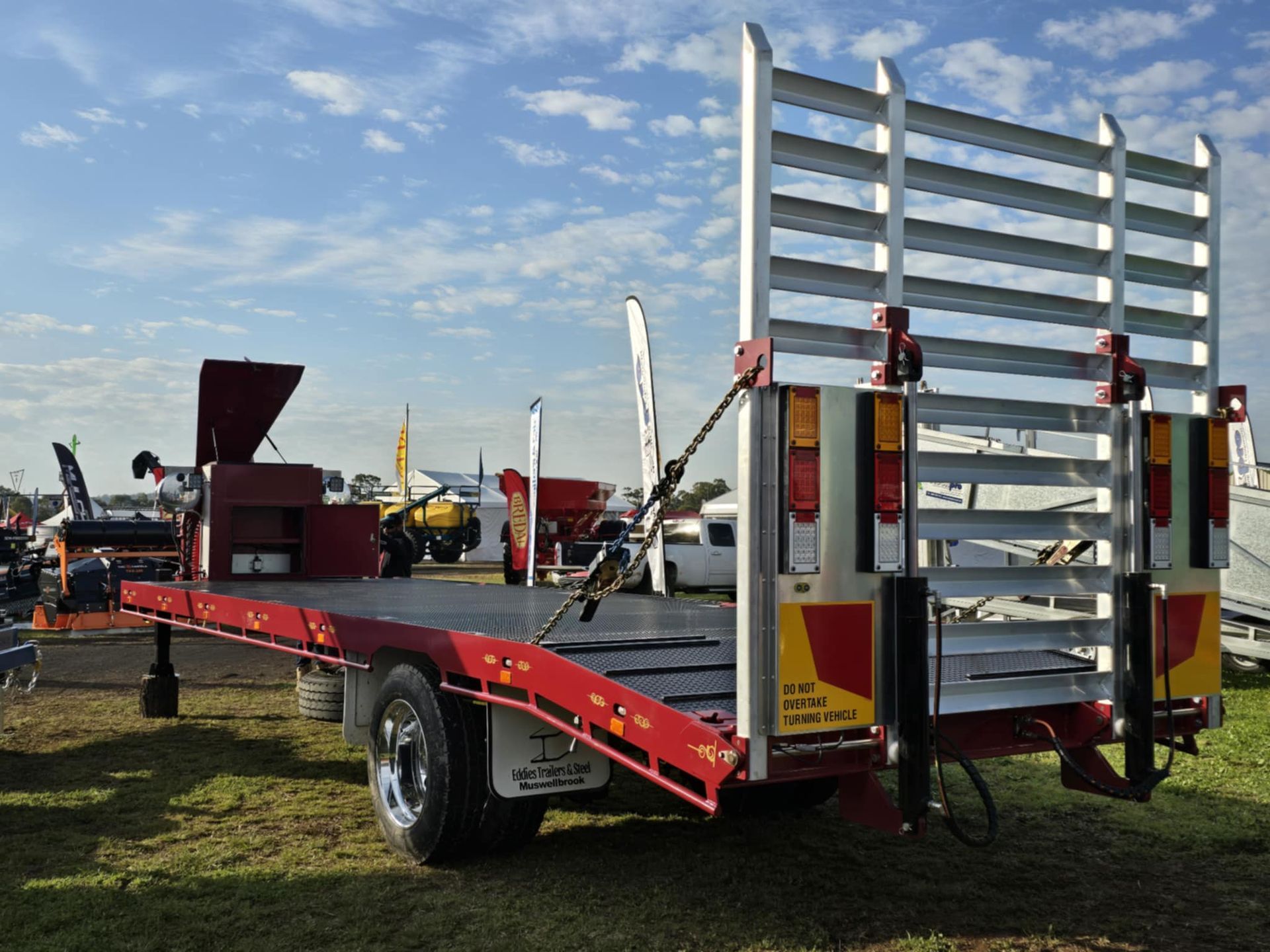 A red and white trailer is parked in a grassy field