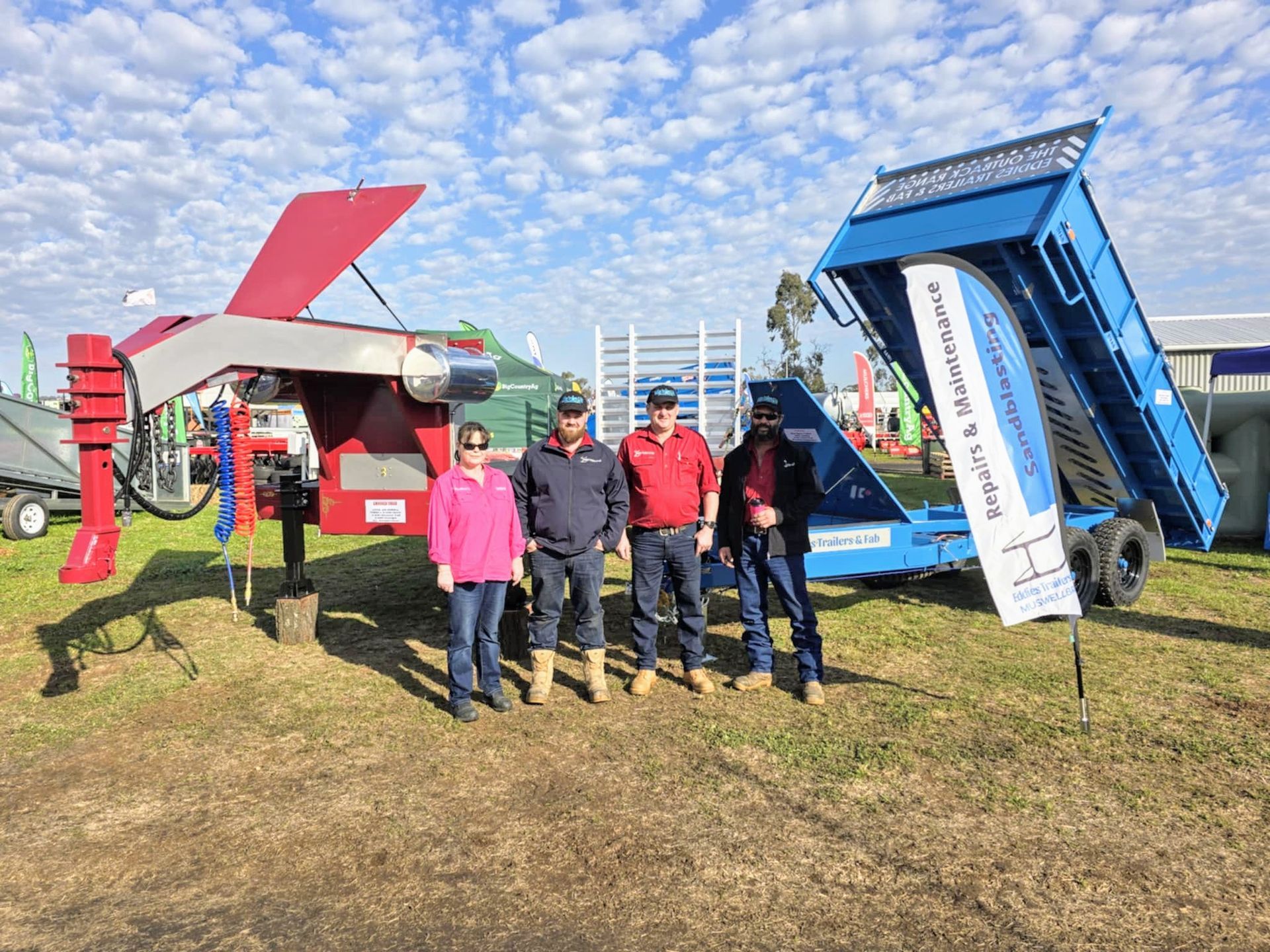 A group of people are standing in front of a dump truck.