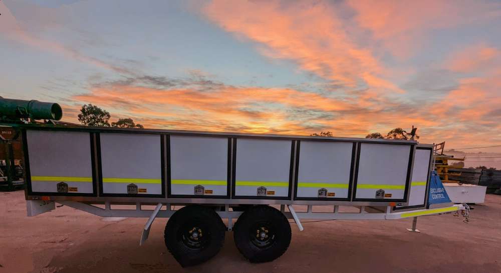 A Trailer Is Parked In A Dirt Field With A Sunset In The Background — Eddies Trailers & Fab in Muswellbrook, NSW