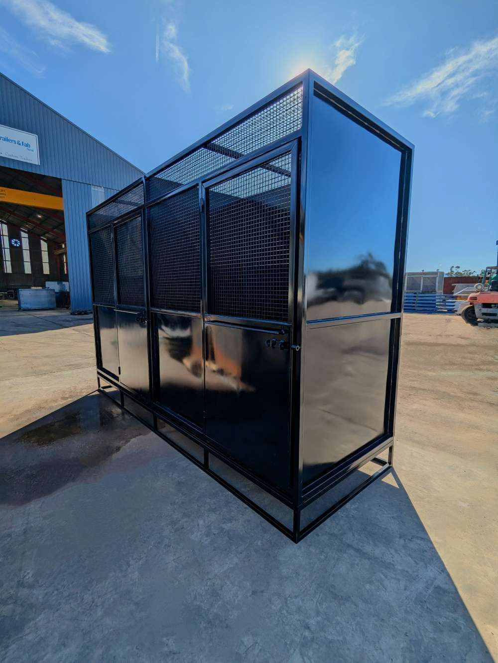 A Black Cage Is Sitting On The Ground In A Parking Lot — Eddies Trailers & Fab in Muswellbrook, NSW