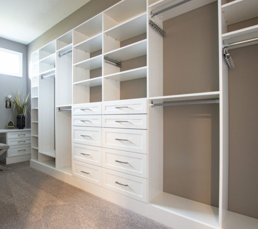 White custom closet system with shelves, drawers, and hanging rods.