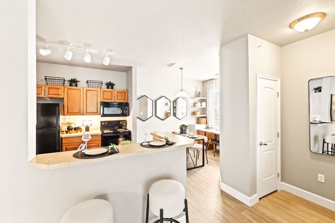Open-concept kitchen with a breakfast bar, wooden cabinets, and dining area.