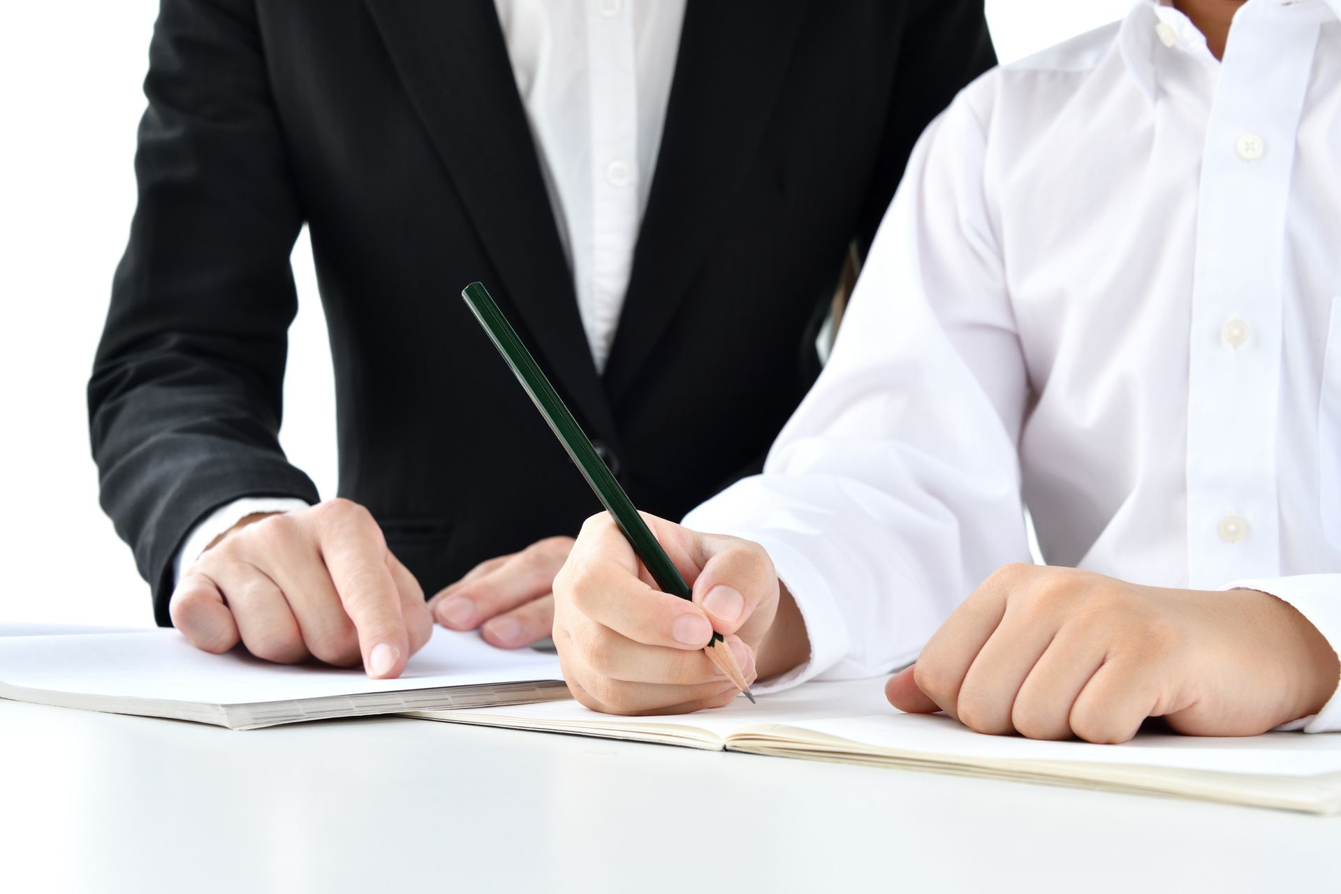 A man and a woman are writing on a piece of paper