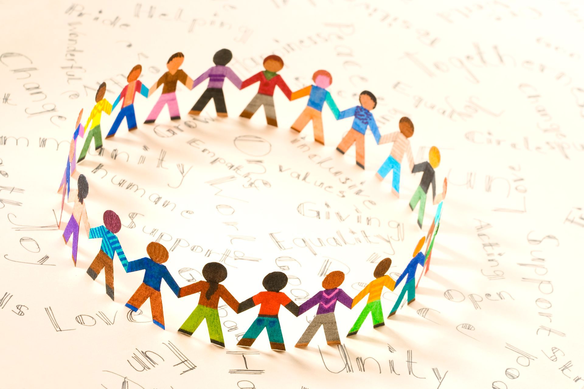 A group of paper people are holding hands in a circle.