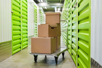 A cart filled with cardboard boxes in a storage room.