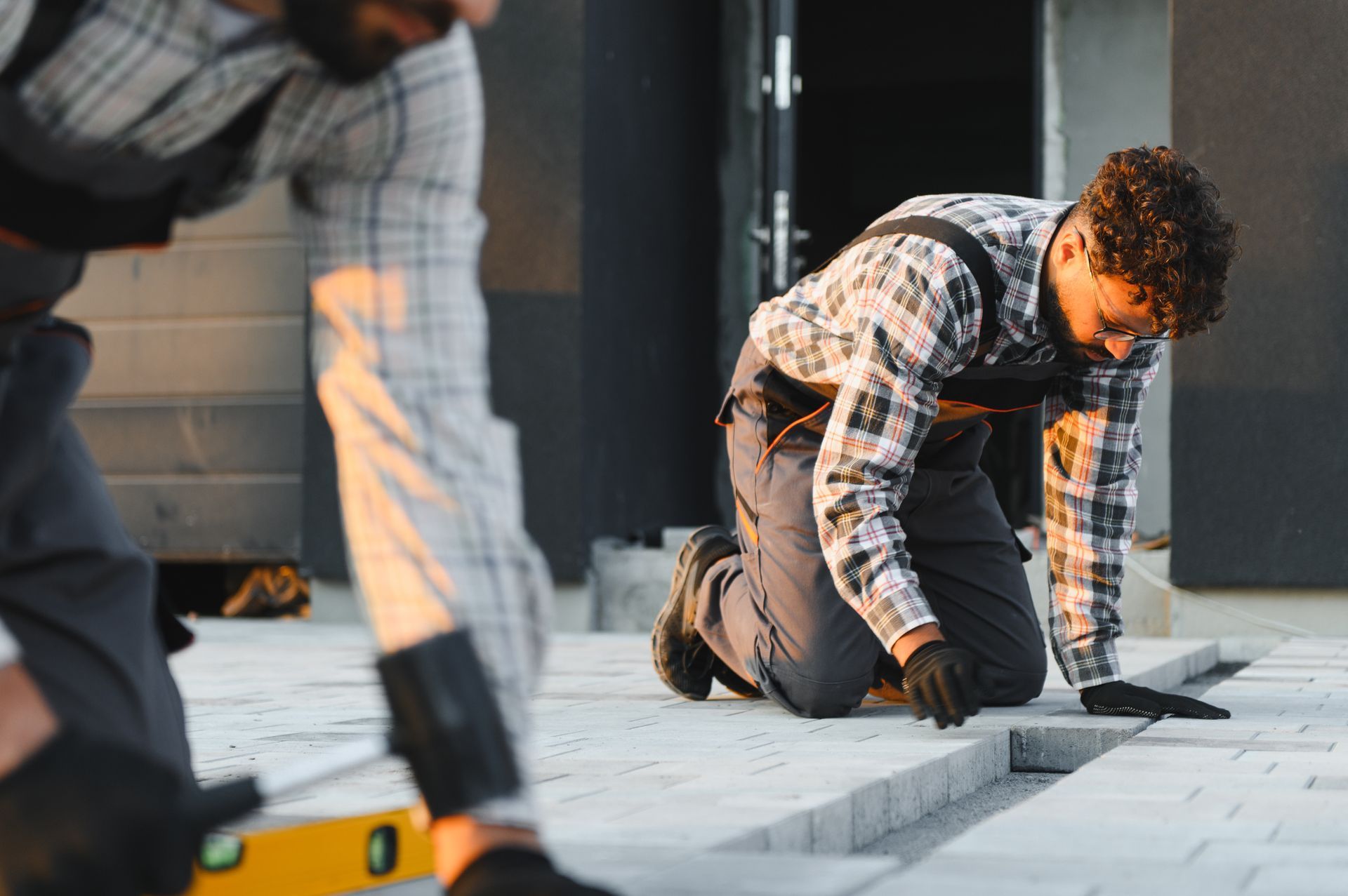 Construction workers laying paving stones on the sidewalk. Construction workers laying paving stones on the sidewalk.