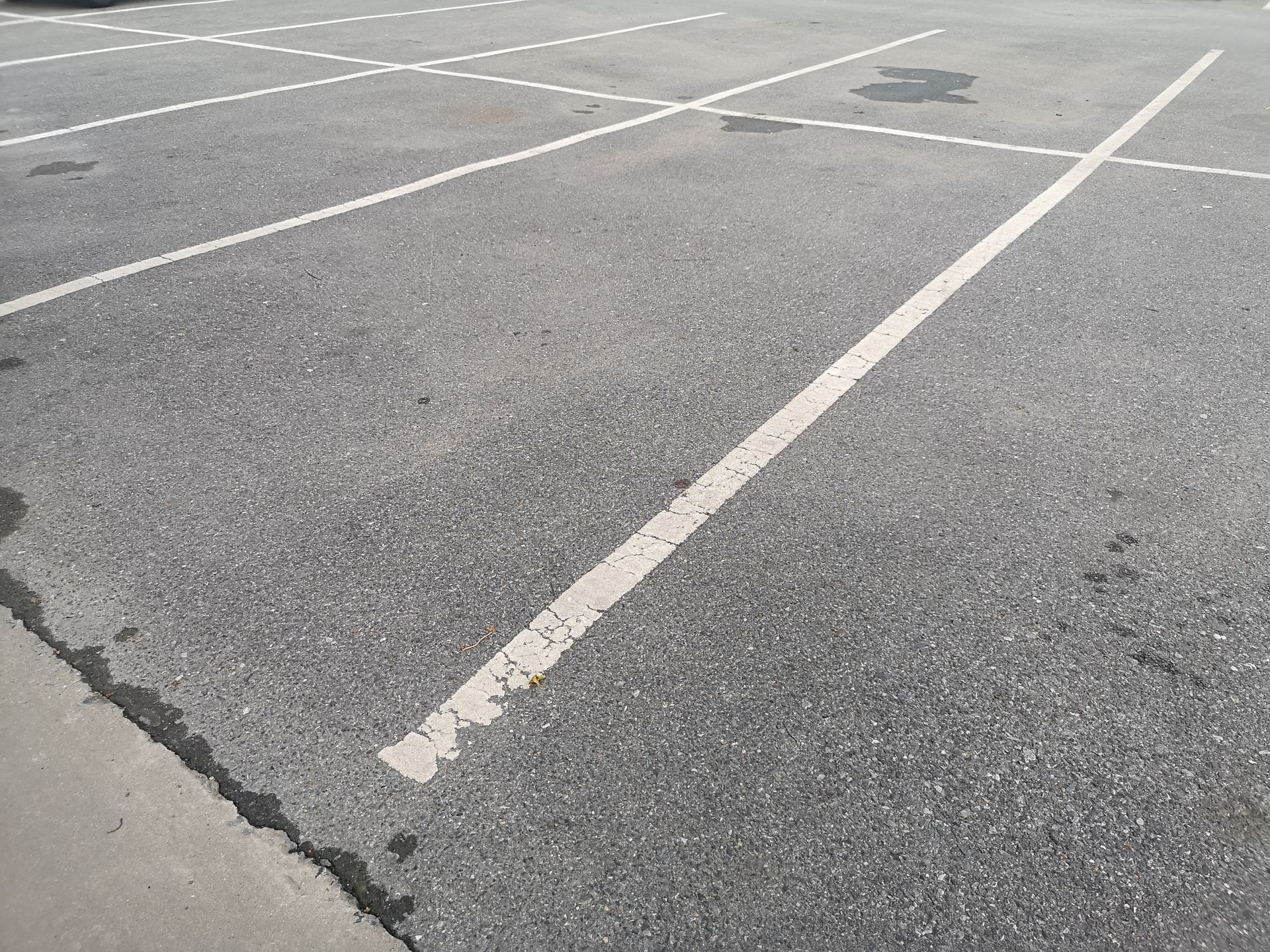 Parking lot with white painted lines on asphalt.