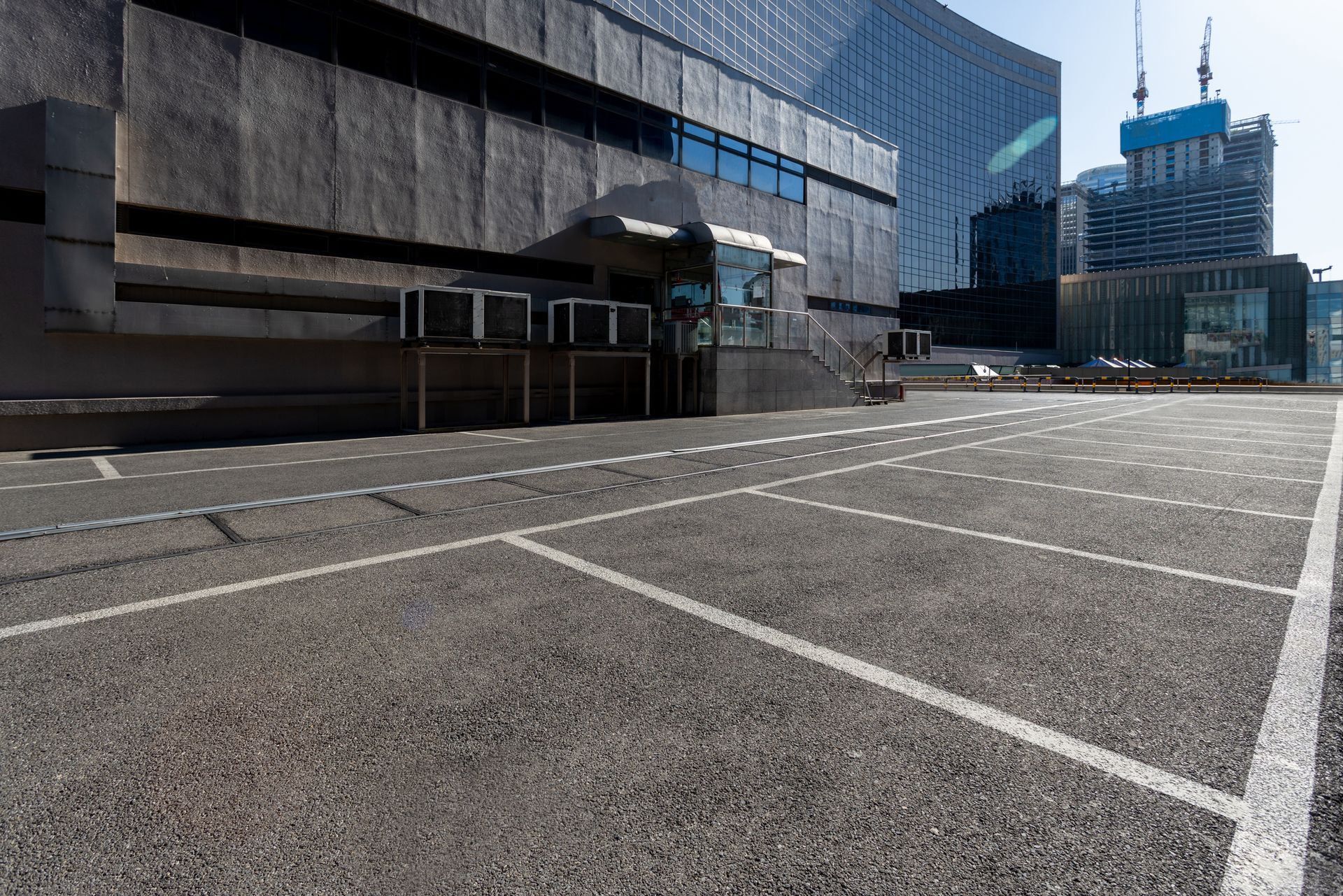 View of a commercial building’s parking lot and other buildings in the background View of a commercial building’s parking lot and other buildings in the background