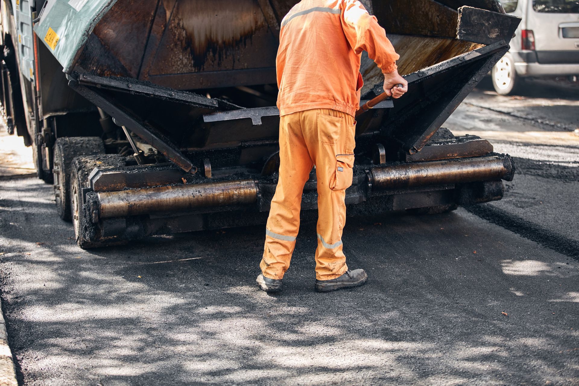 Commercial paving contractor working on a new asphalt layer on a public street.