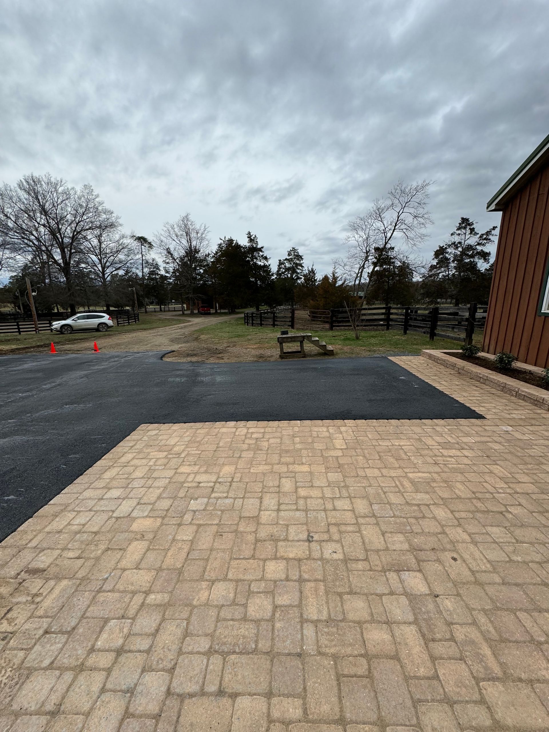 A driveway with a brick walkway leading to a house.