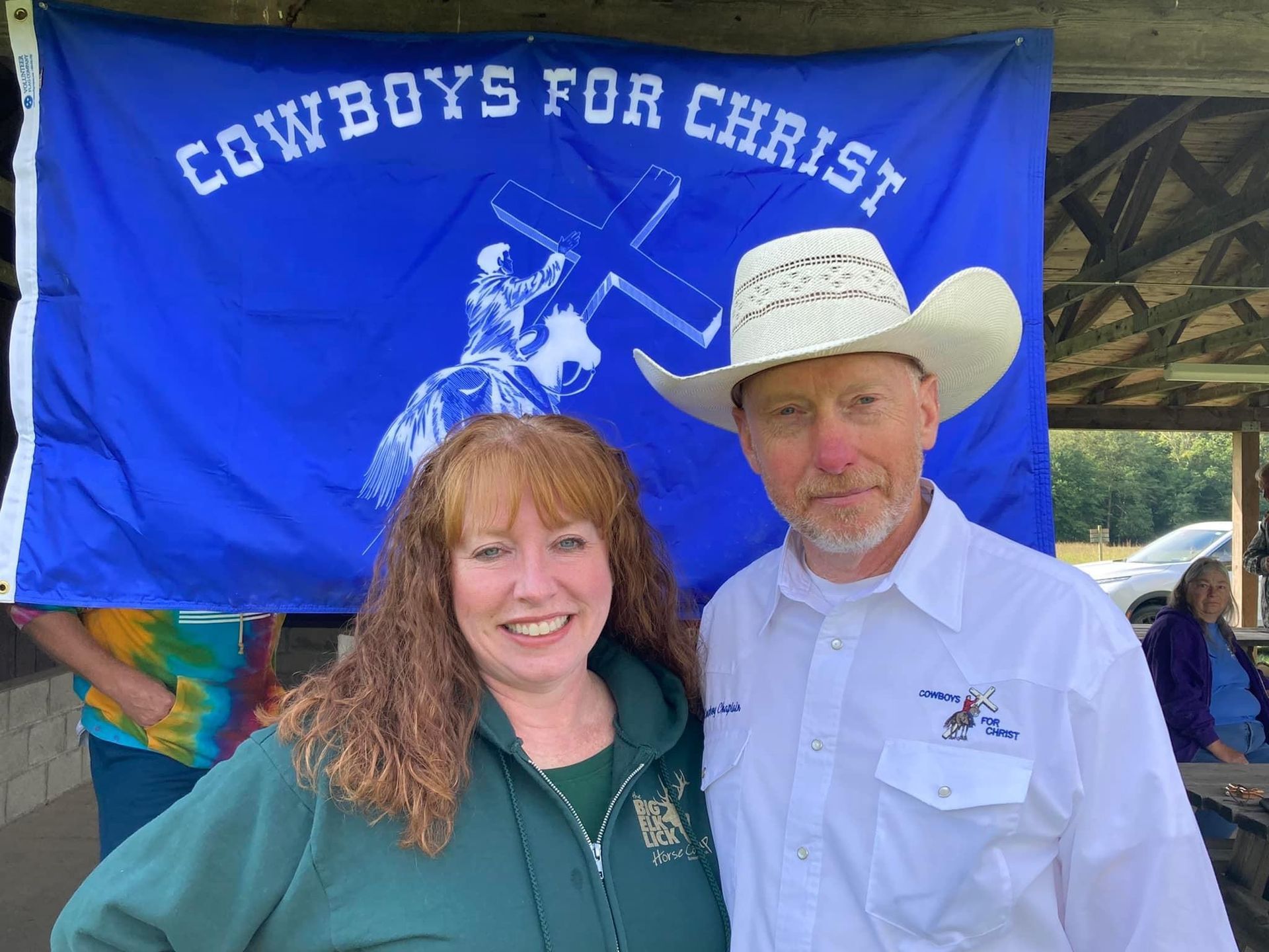 Woman and man pose in front of a 
