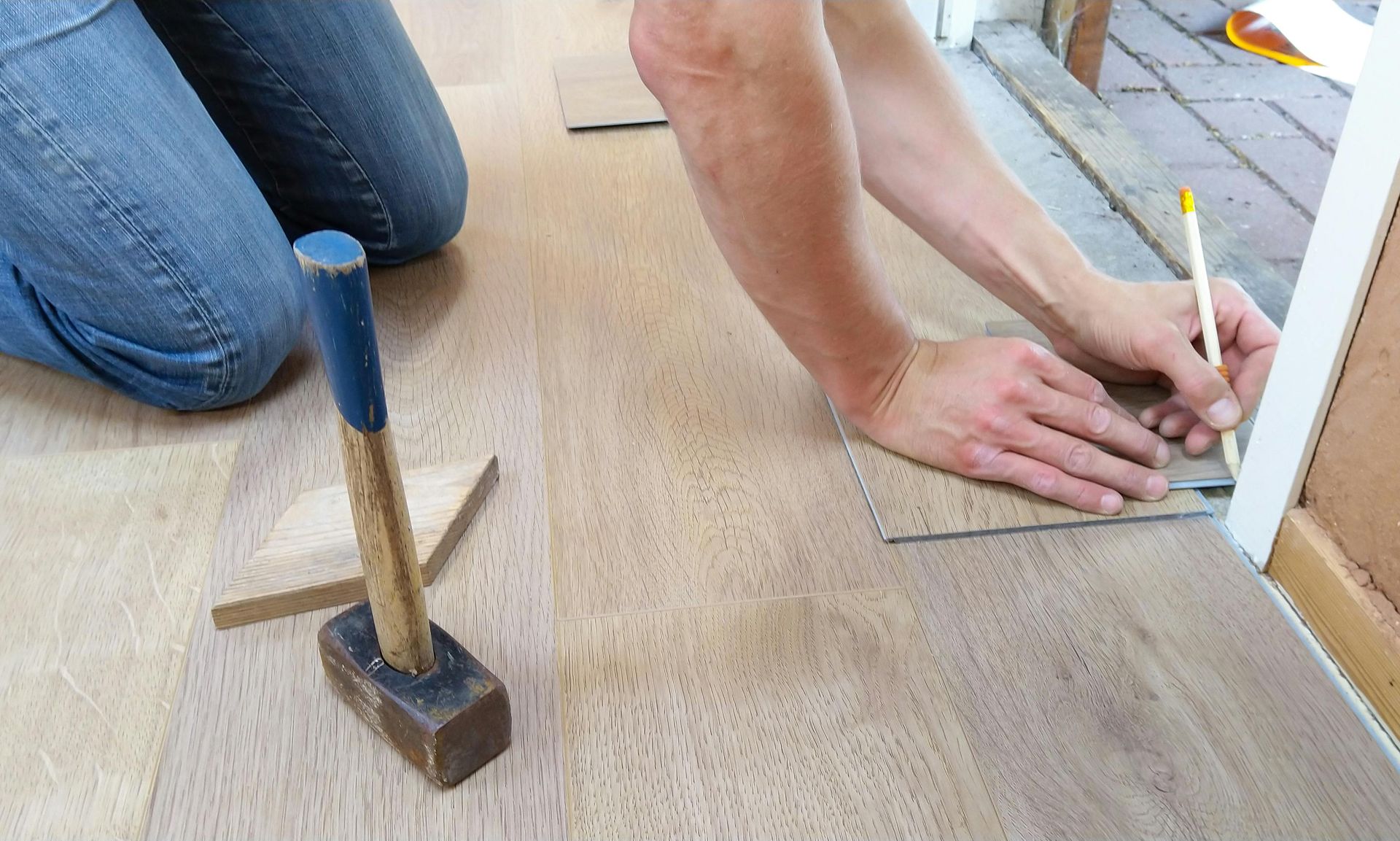 A Person Kneeling on a Wood-look Floor — RAC Carpentry Services in Helensvale, QLD