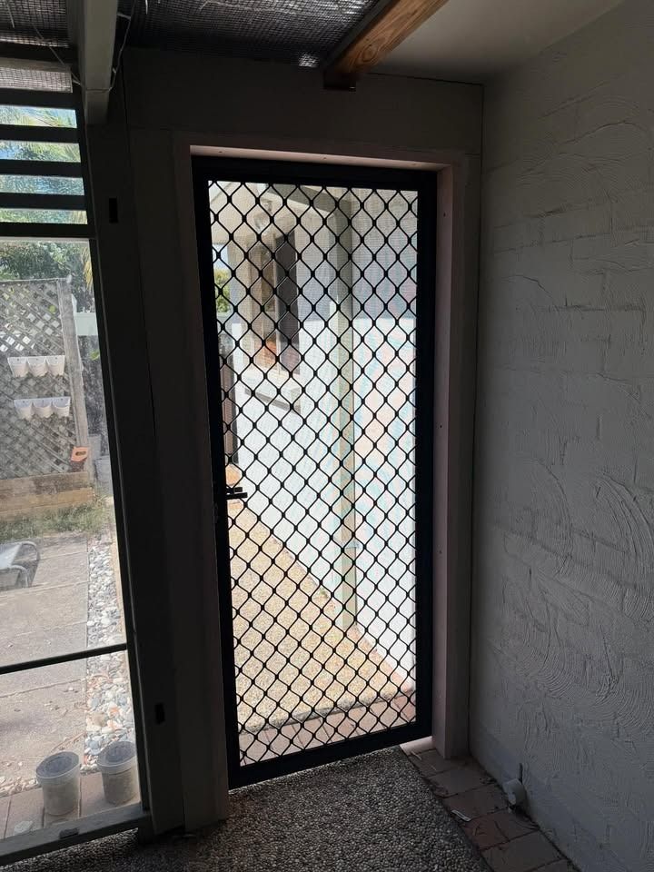 Black Security Screen Door in a Doorway — RAC Carpentry Services in Pimpama, QLD