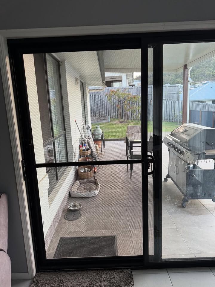 Black Sliding Door Open Onto a Patio — RAC Carpentry Services in Pimpama, QLD