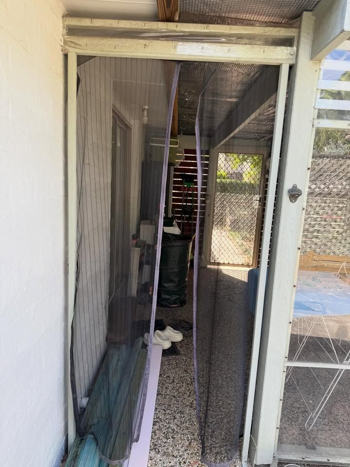 Damaged Screen Door Partially Open — RAC Carpentry Services in Oxenford, QLD