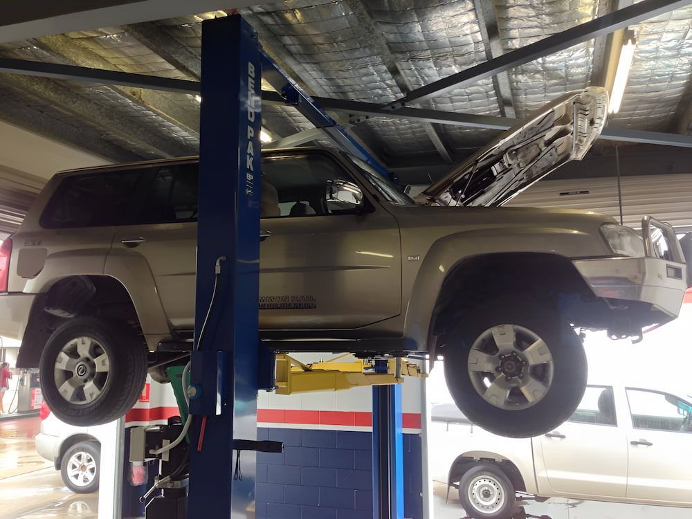 A Car is on a Lift in a Garage With the Hood Up — Mr Shiny Mechanical in Andergrove, QLD
