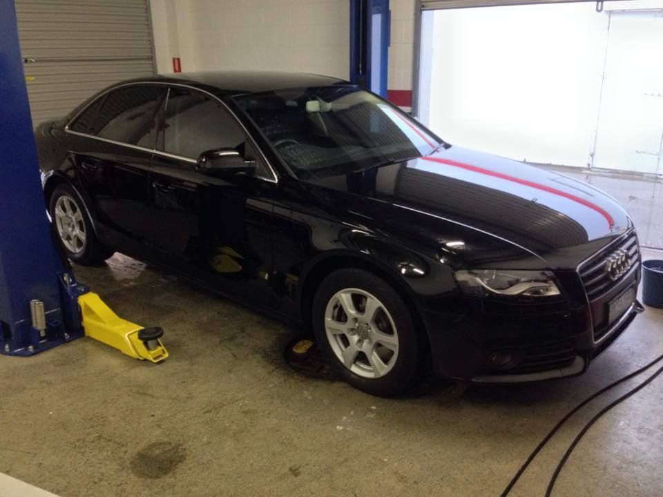A Black Car is Sitting on a Lift in a Garage — Mr Shiny Mechanical in Paget, QLD