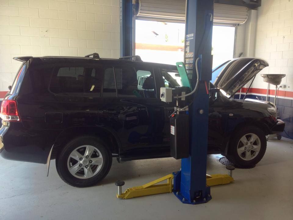 A Black Suv is on a Lift in a Garage — Mr Shiny Mechanical in Andergrove, QLD