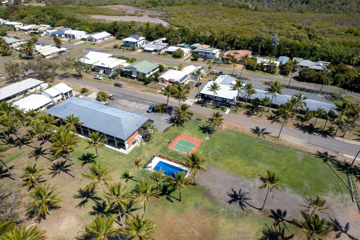 An Aerial View of a Residential Area With Palm Trees and Houses — Mr Shiny Mechanical in Sarina, QLD