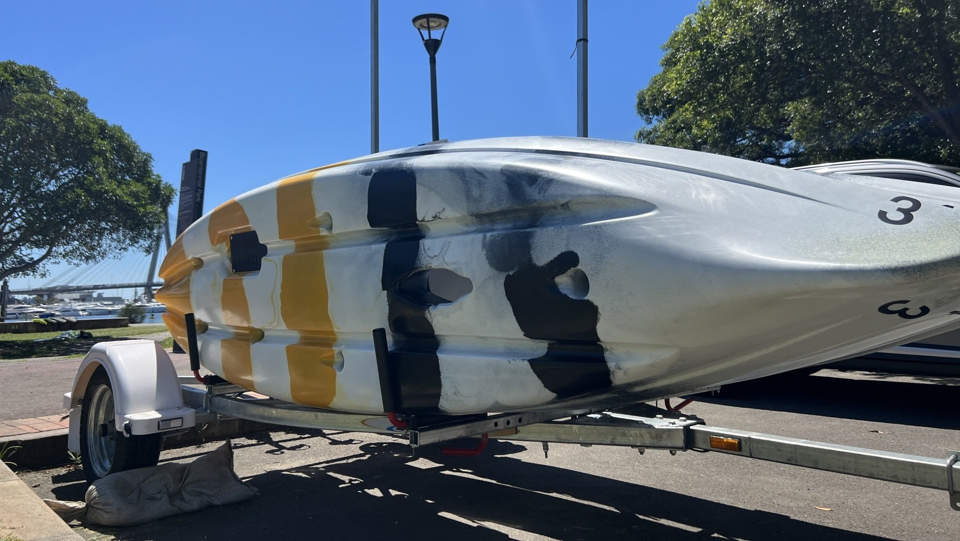 HBR PNY kayaks secured on a trailer, set against the backdrop of Sydney Harbour