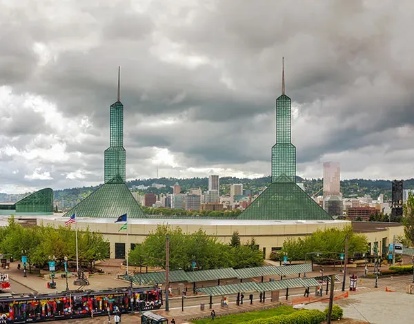 Oregon Convention Center in Portland, with two tall green glass towers, a round building