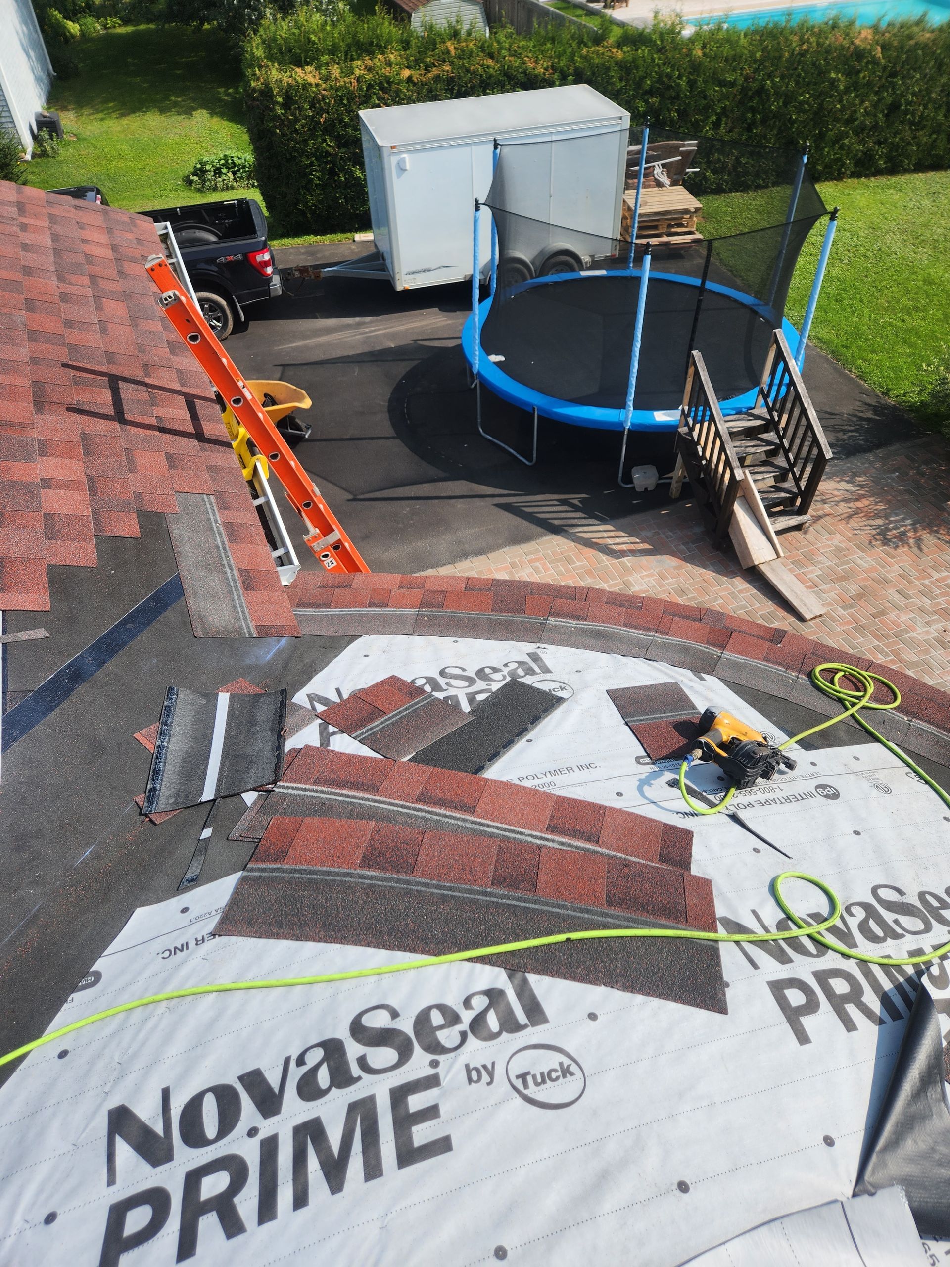 A trampoline is sitting on top of a roof that is being repaired.