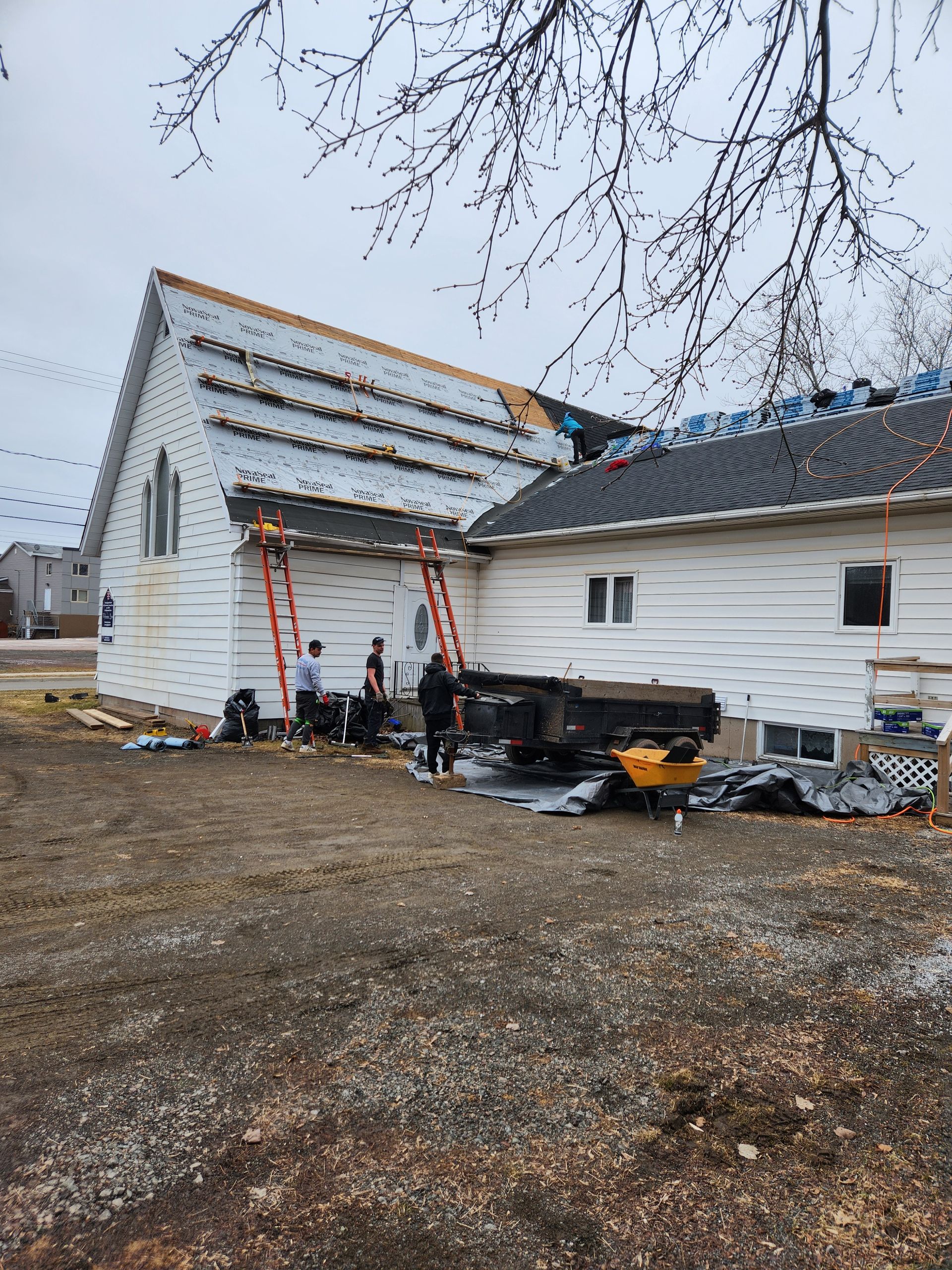 A group of people are working on the roof of a house.