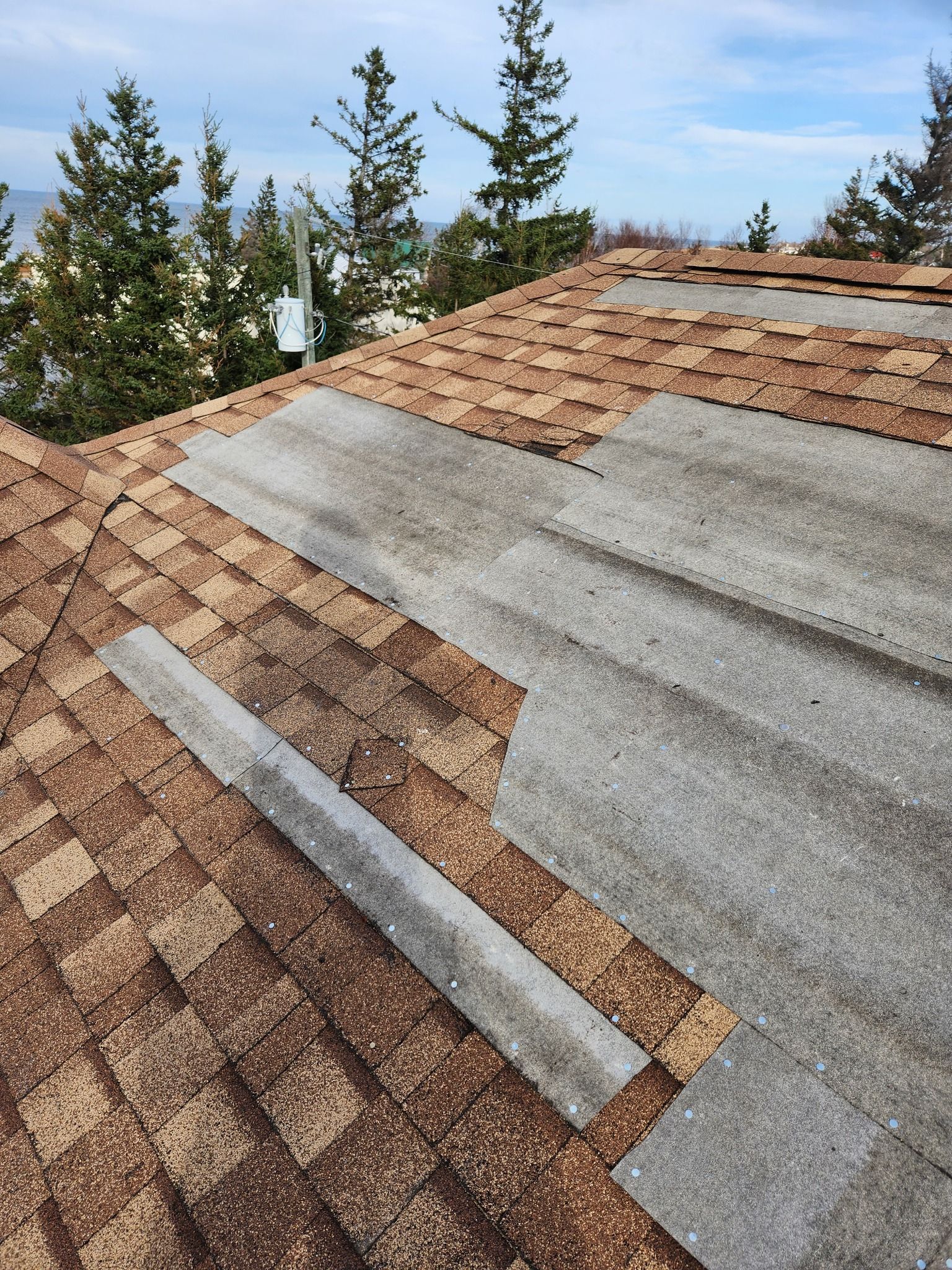 A close up of a roof with a few pieces of shingles missing.