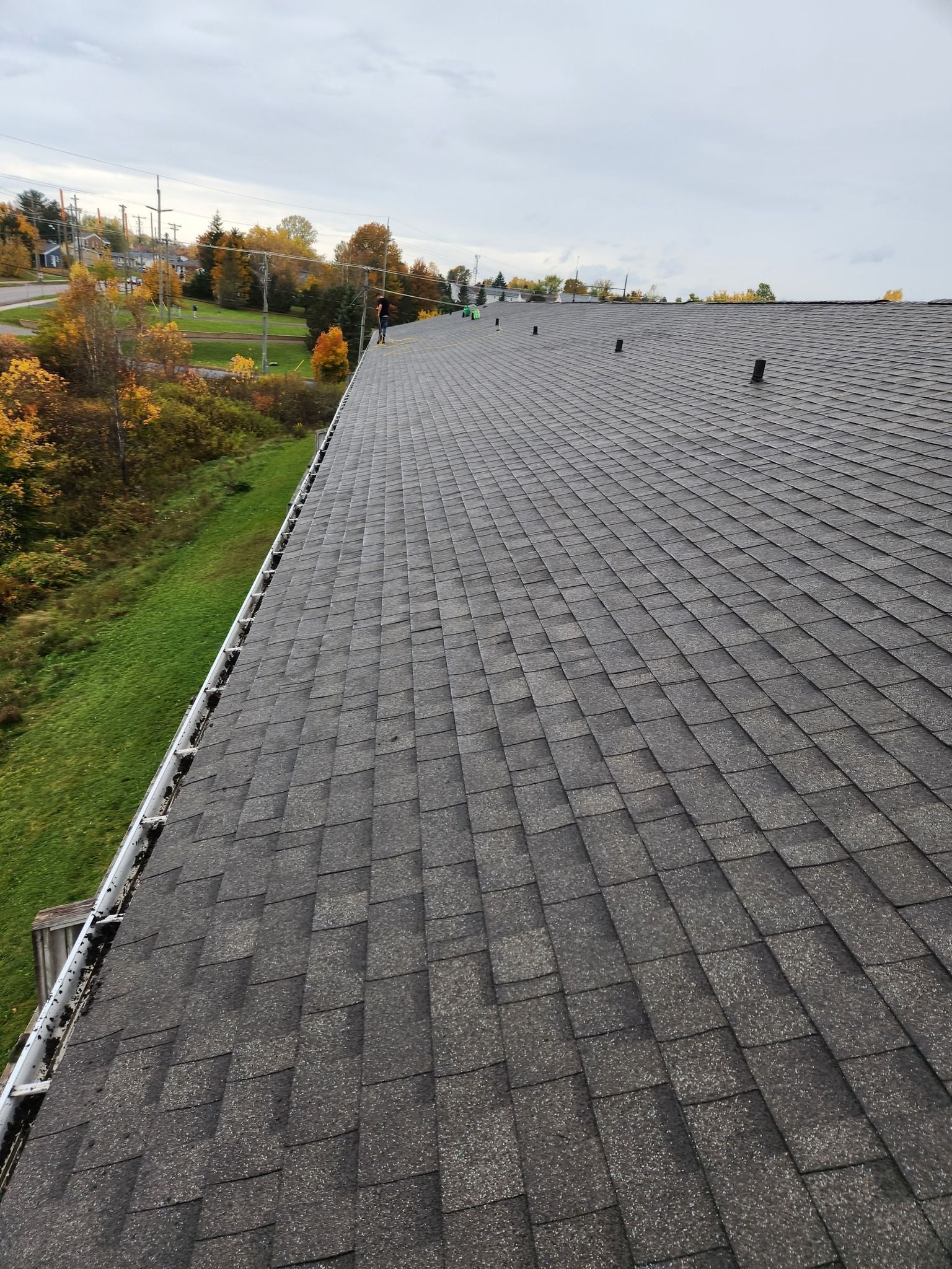 A roof with a lot of shingles and a gutter on it.