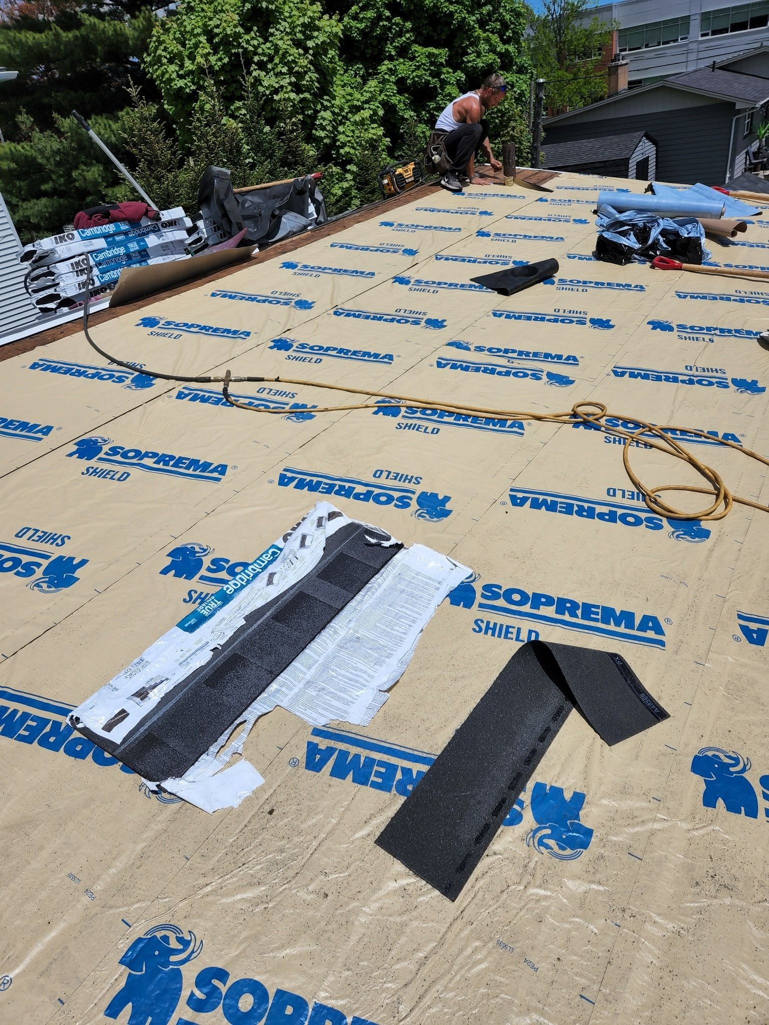 A man is working on the roof of a house.