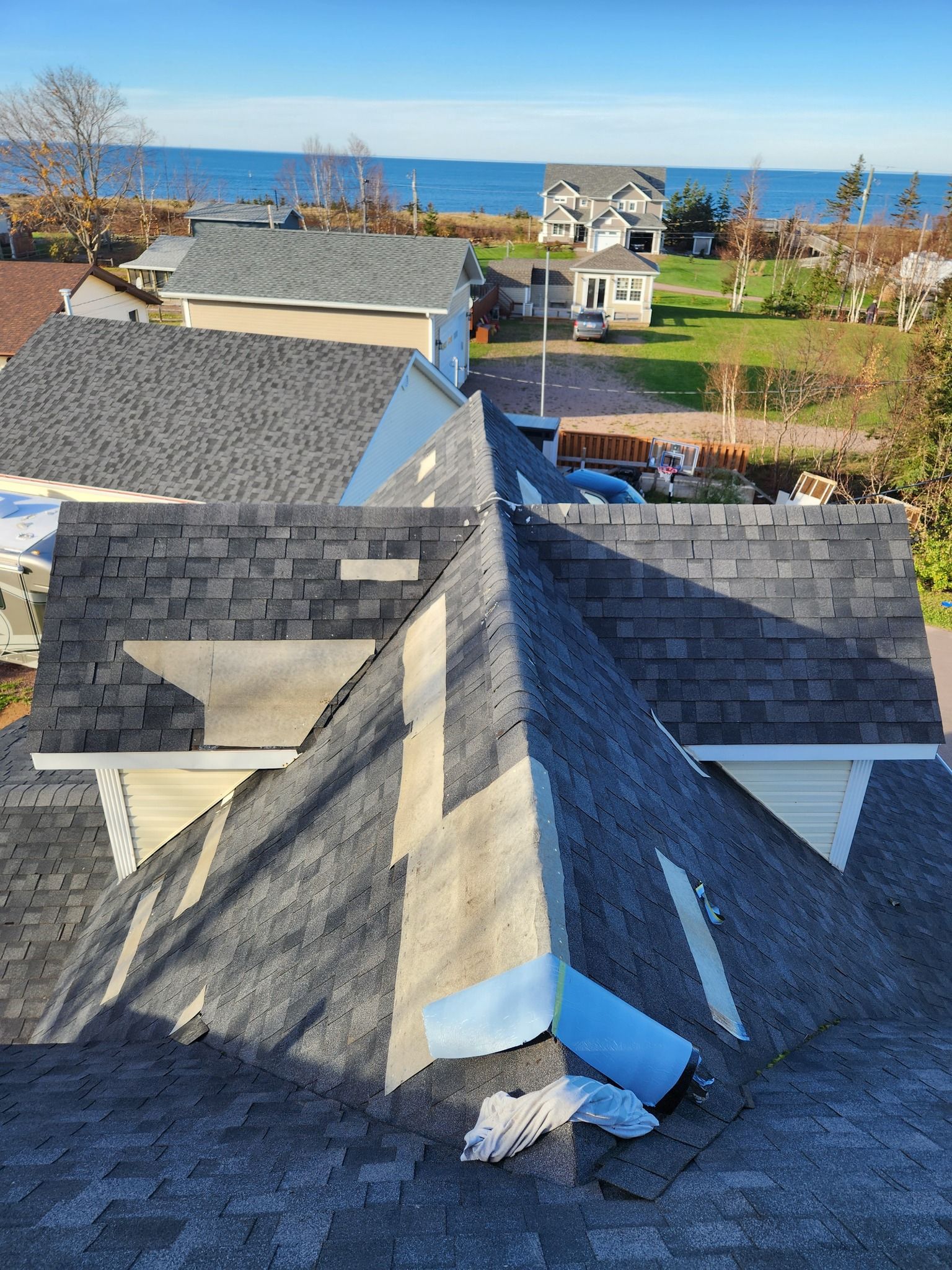 A roof of a house with a view of the ocean.