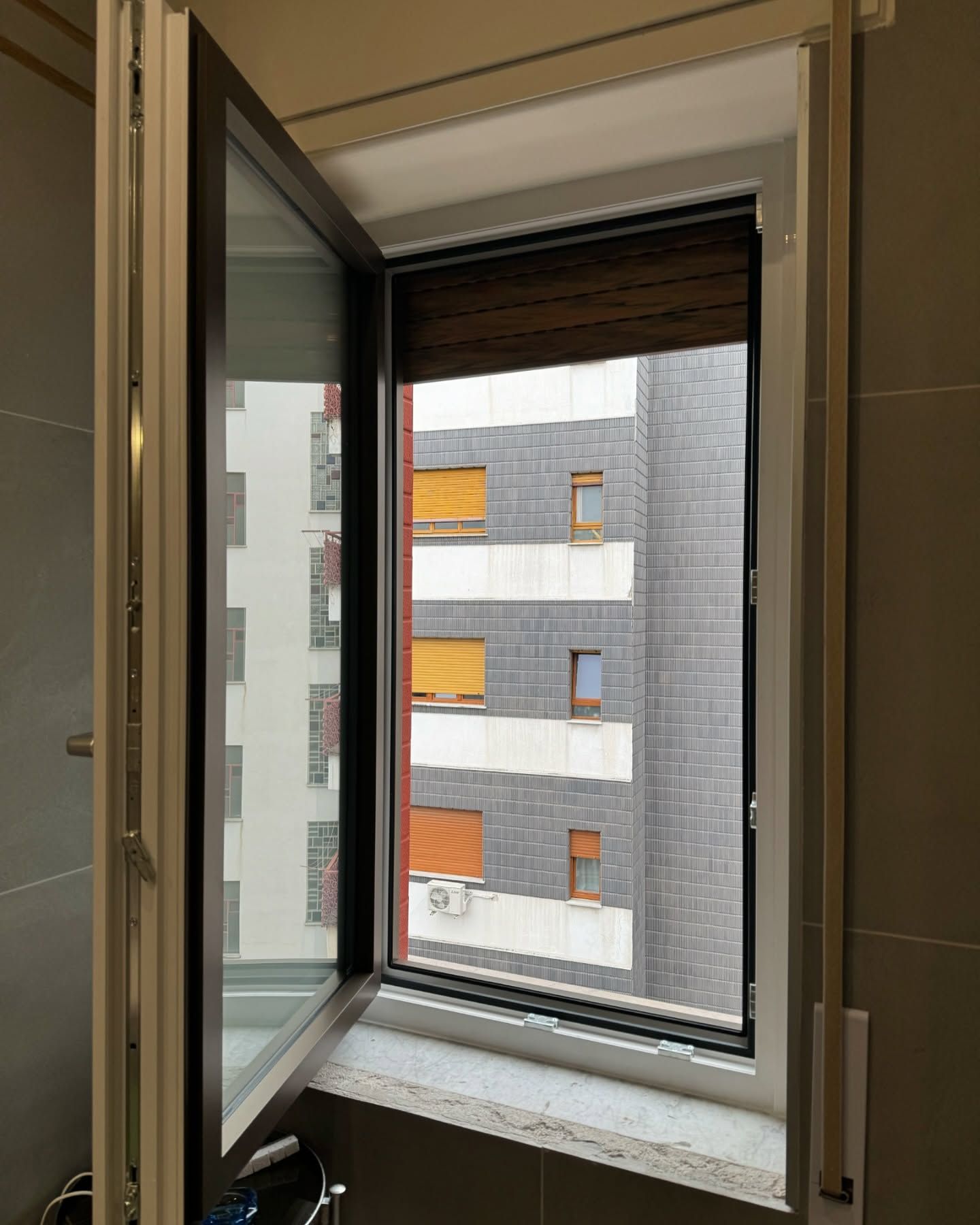 La finestra è aperta e si affaccia su un edificio.