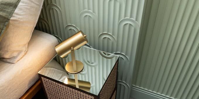 Un comodino con una lampada accanto al letto.