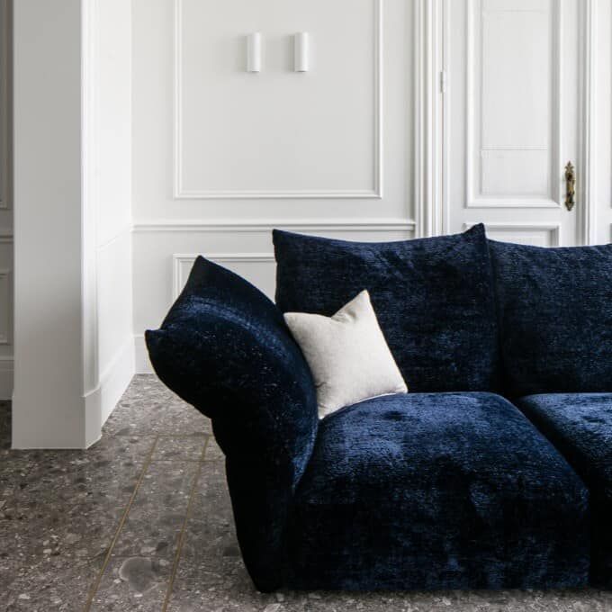 Un divano blu con cuscini bianchi è posizionato nel soggiorno.