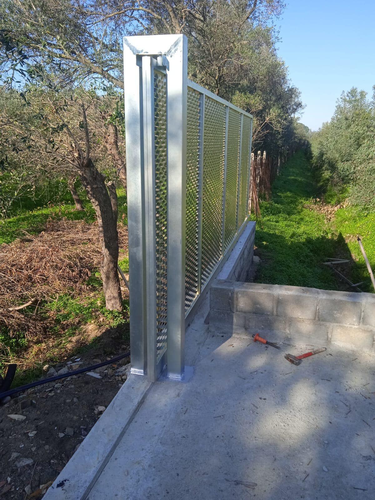 In mezzo a un campo viene costruita una recinzione metallica.