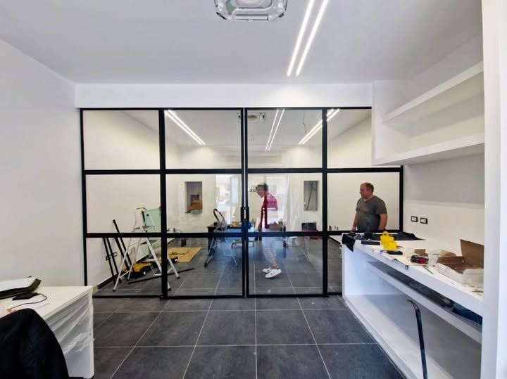 Un uomo è in piedi in una stanza con una porta scorrevole in vetro.