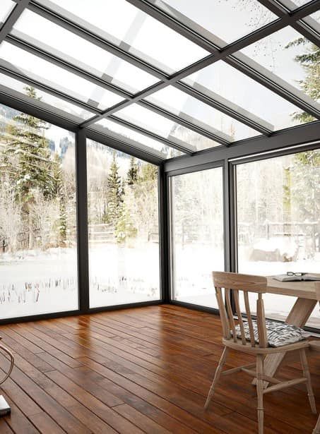 C'è un tavolo e delle sedie nella stanza con il tetto in vetro.