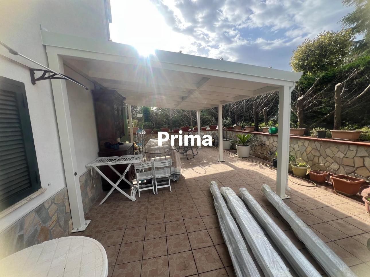 Un patio con tavolo e sedie sotto un pergolato.