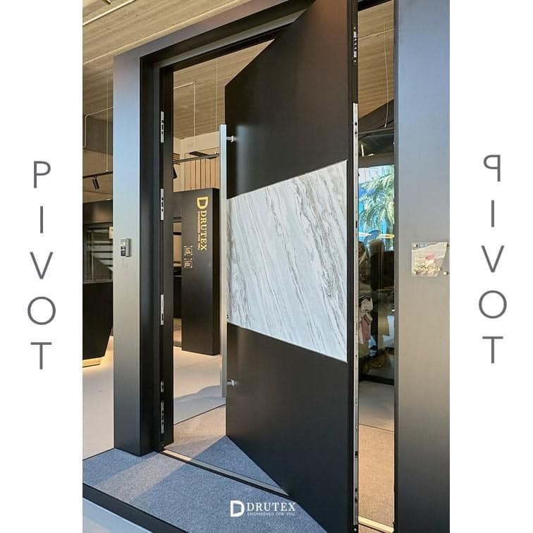 Una porta nera con un bordo di marmo bianco è aperta su una stanza.