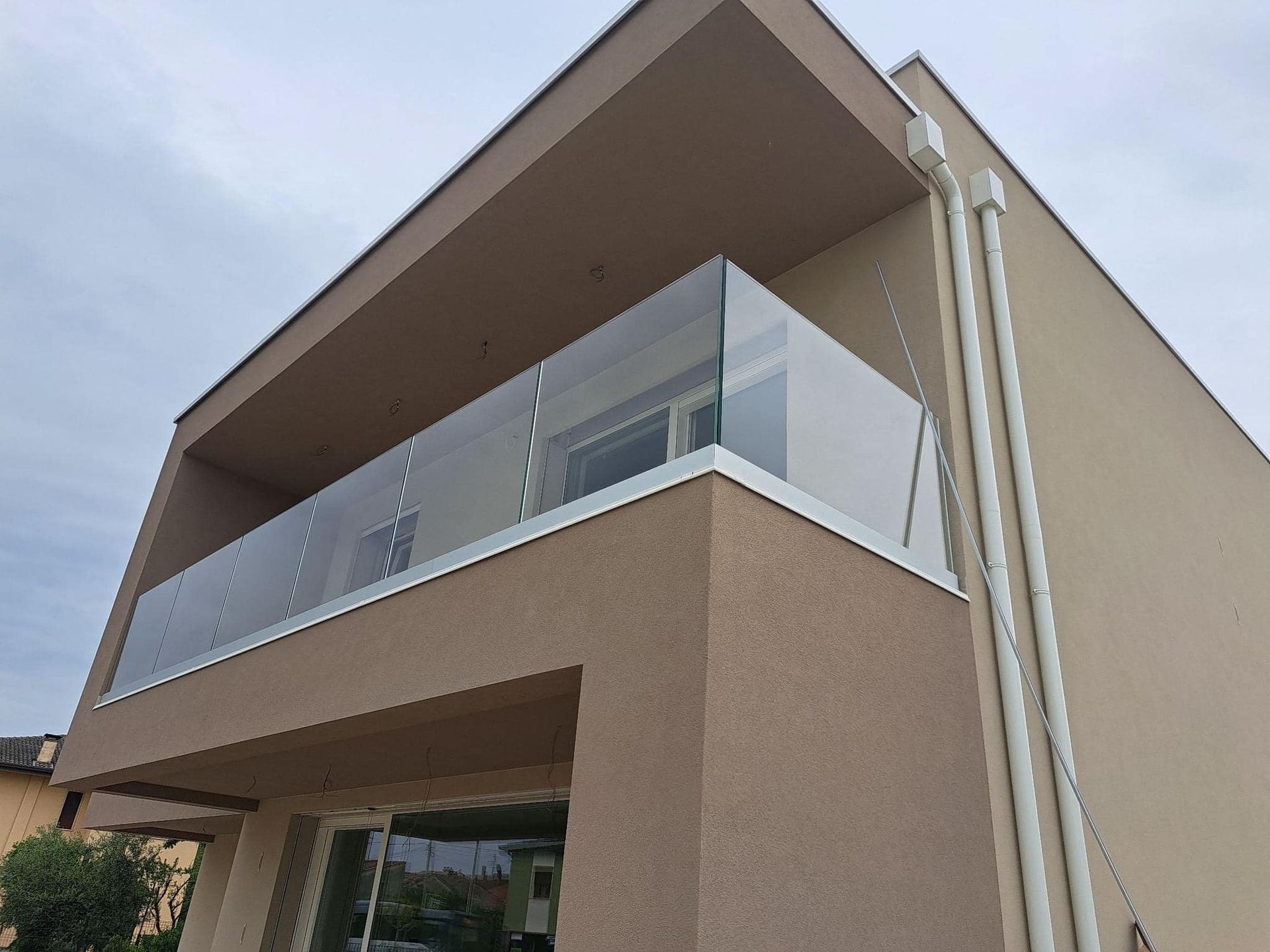 Una casa con un balcone e una ringhiera in vetro