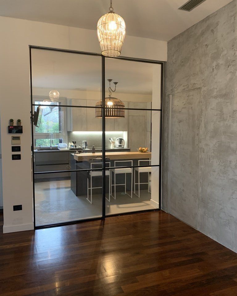Una stanza con una porta scorrevole in vetro che conduce alla cucina