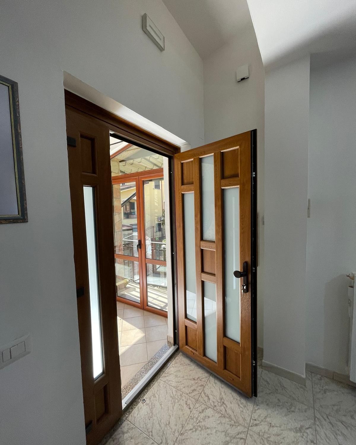 Un corridoio con una porta di legno aperta